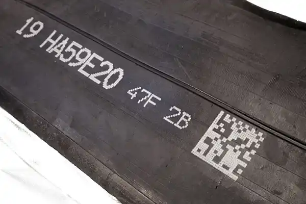 Uncured rubber marked in white ink with the Matthews V-Series drop on demand inkjet printer to show alphanumeric text 2D code