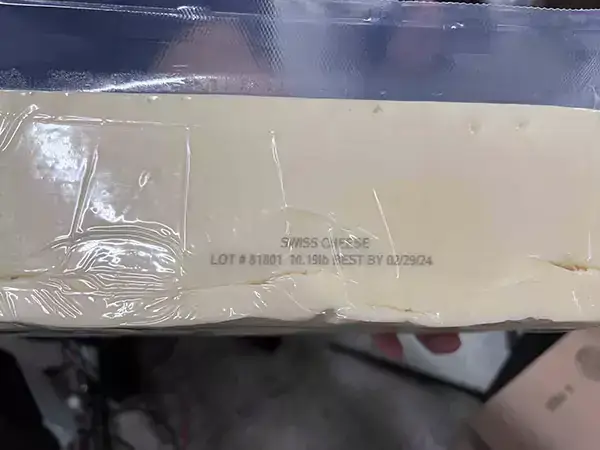 Package of cheese with date and barcode printed on plastic. 